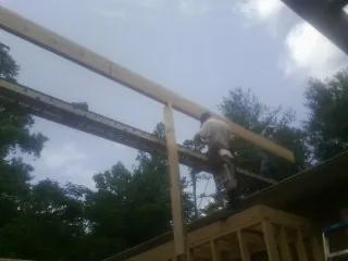 Carpenter setting a ridge beam over a new addition frame — Ice Dam Removal by Roofing Brothers in Shippensburg