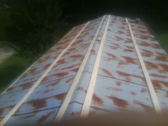 Rusted metal roof panels with new wood purlins before replacement — Storm Damage Roof Repair in Shippensburg by Roofing Brothers