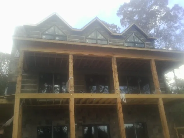 Dormers and porch framing on a large log home under construction — Roof Coating work by our crew in Shippensburg