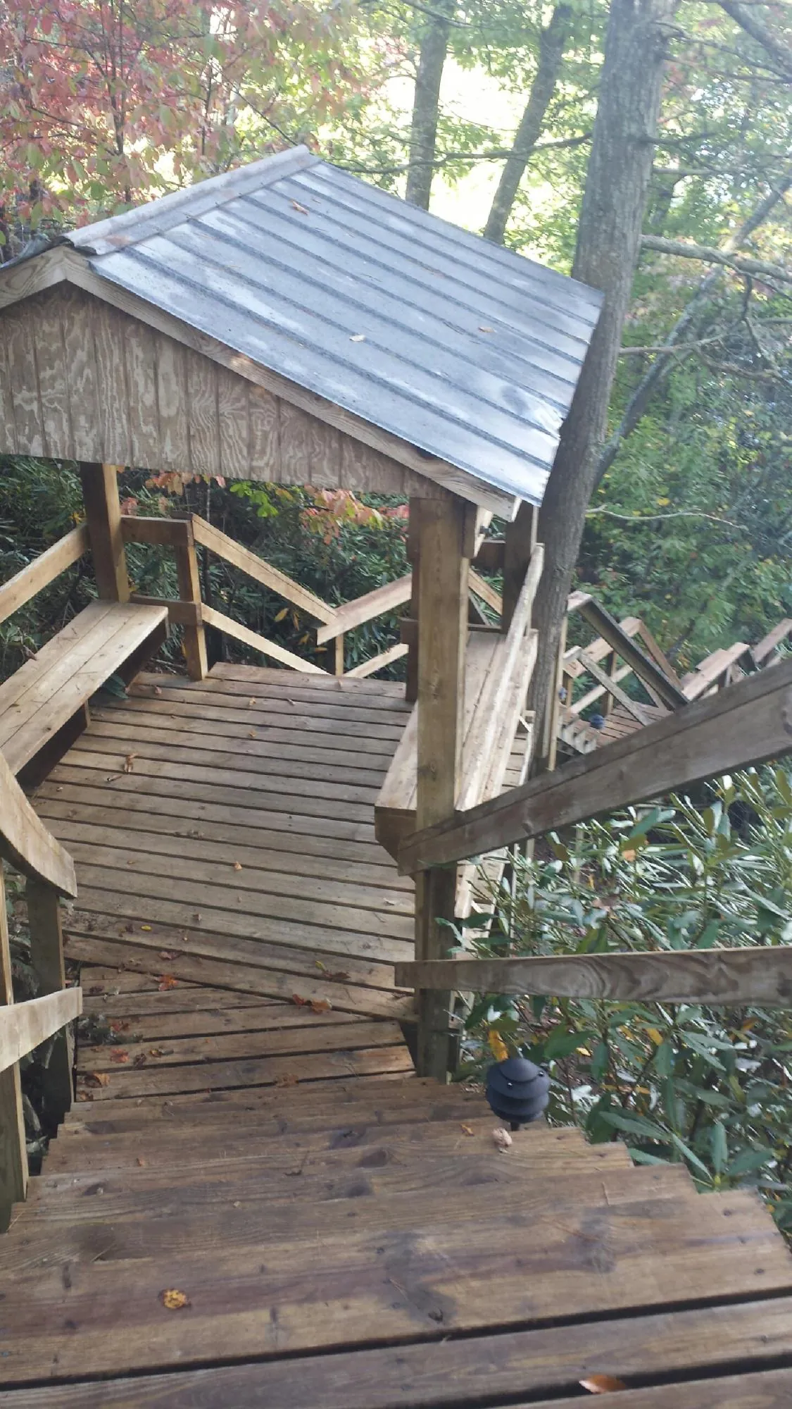 Metal roofed shelter over wooden steps on a wooded walkway — Skylight Repair & Installation work by our crew in Shippensburg