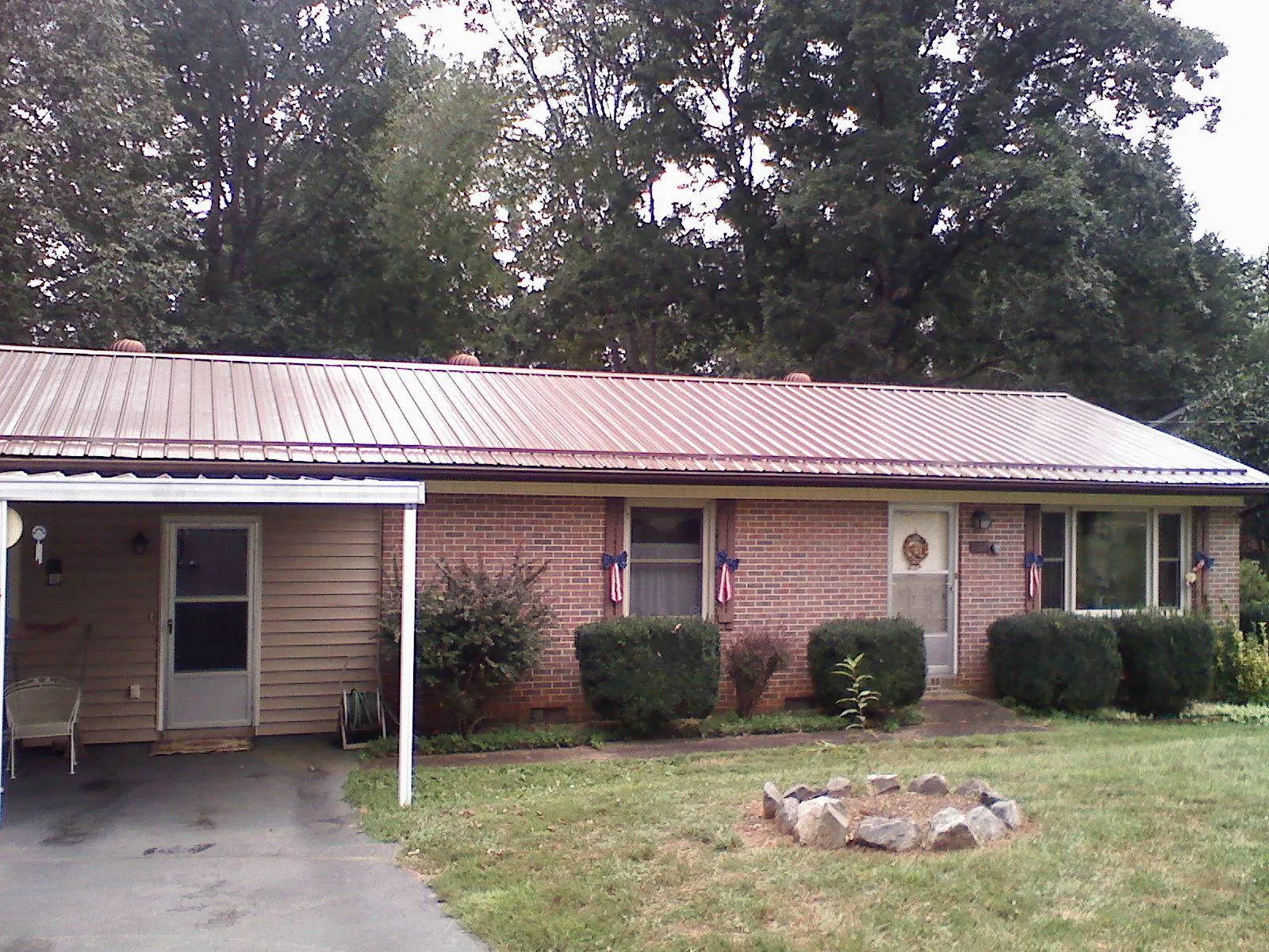 Bronze metal roof and carport on a brick ranch home — Roof Repair work by our crew in Shippensburg